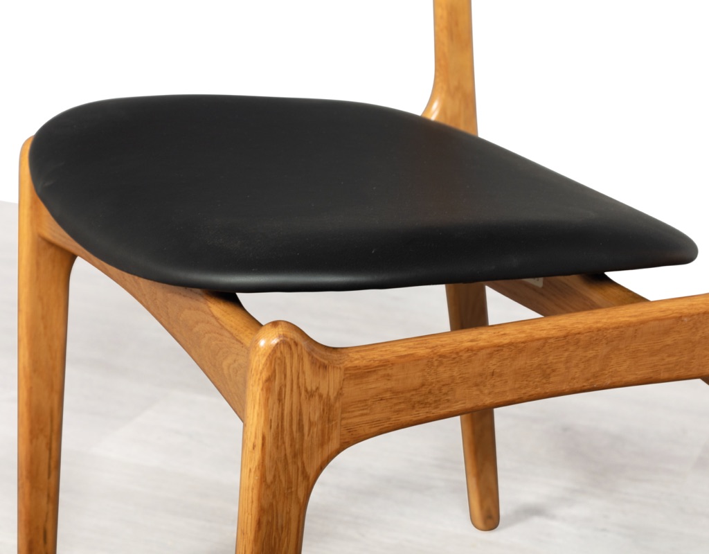 Mid century modern Erik Buch Model 49 dining chairs Danish vintage 1960 seating O.D. Mobler Oddense Mobelfabrik European oak leather set of eight carver armchairs close up of floating seat
